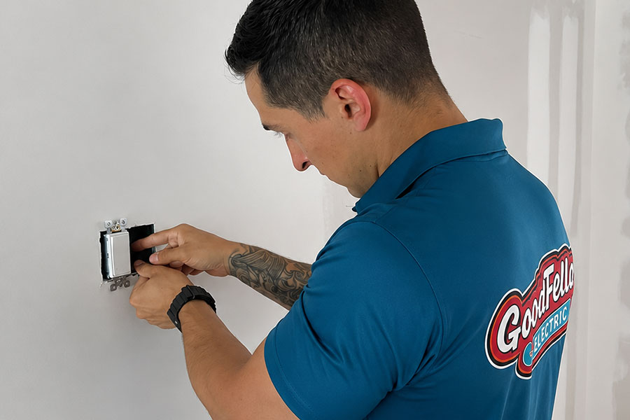Electrician working on wall outlet